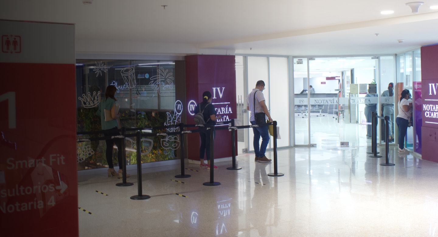 Personas esperando su turno para realizar trámites en la entrada de la Notaria 4 de Barranquilla